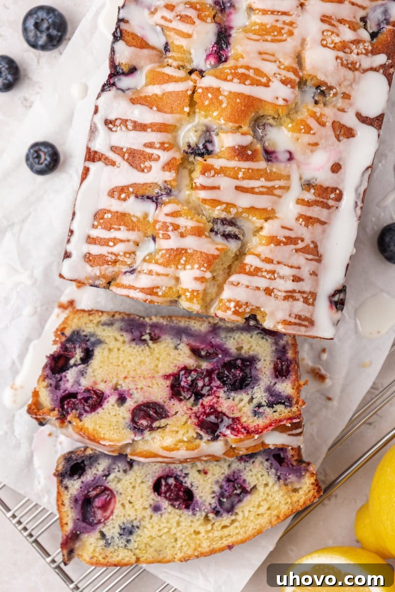 overhead view of partially sliced blueberry loaf cake with a lemon glaze