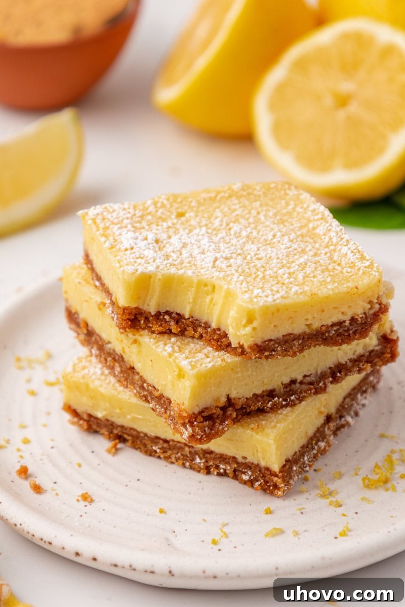 Tangy Lemon Icebox Bars Recipe — Cool, Zesty Dessert with Shortbread Crust 2 stack of three creamy lemon icebox bars with graham cracker crust