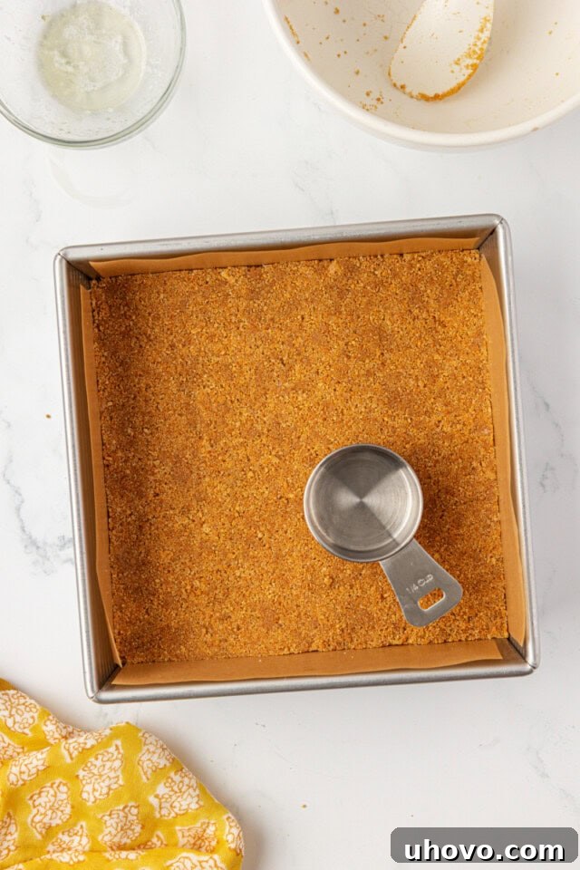 Tangy Lemon Icebox Bars Recipe — Cool, Zesty Dessert with Shortbread Crust 4 overhead view of graham cracker crust mixture pressed into a square baking pan