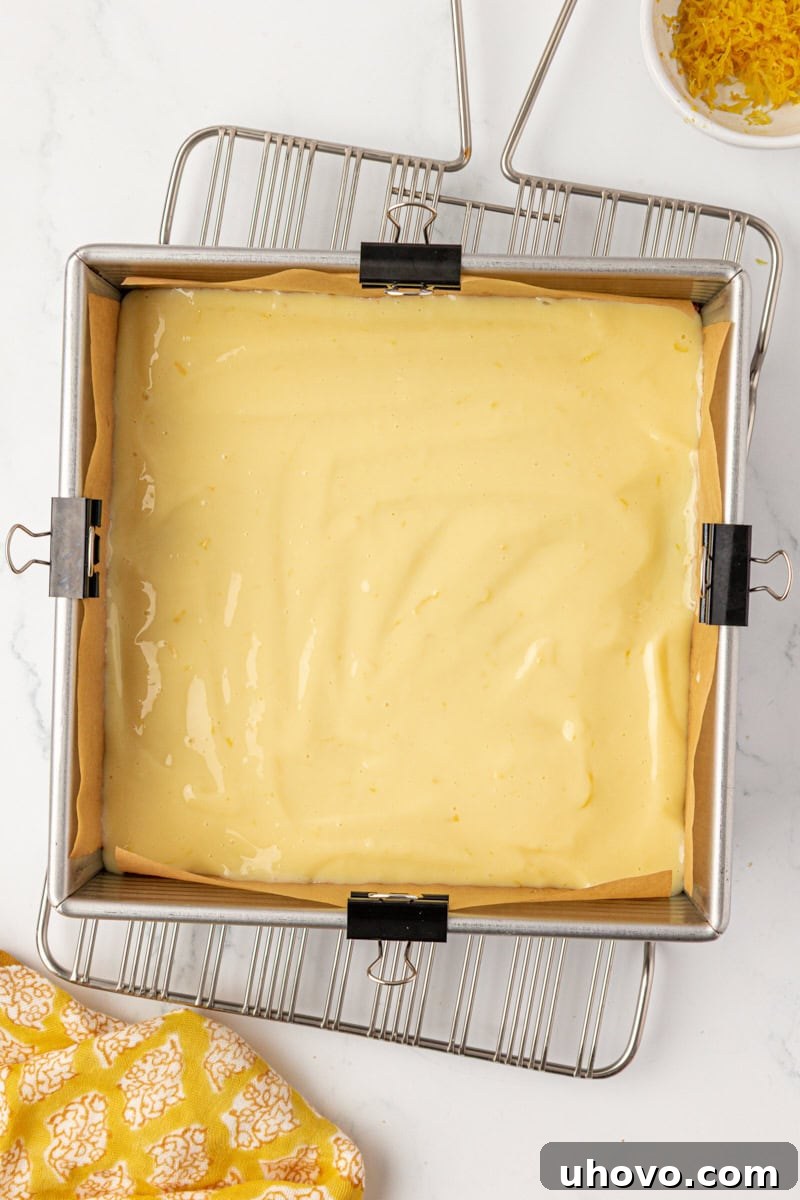 Tangy Lemon Icebox Bars Recipe — Cool, Zesty Dessert with Shortbread Crust 6 overhead view of lemon icebox bars in a square baking pan before going into the oven