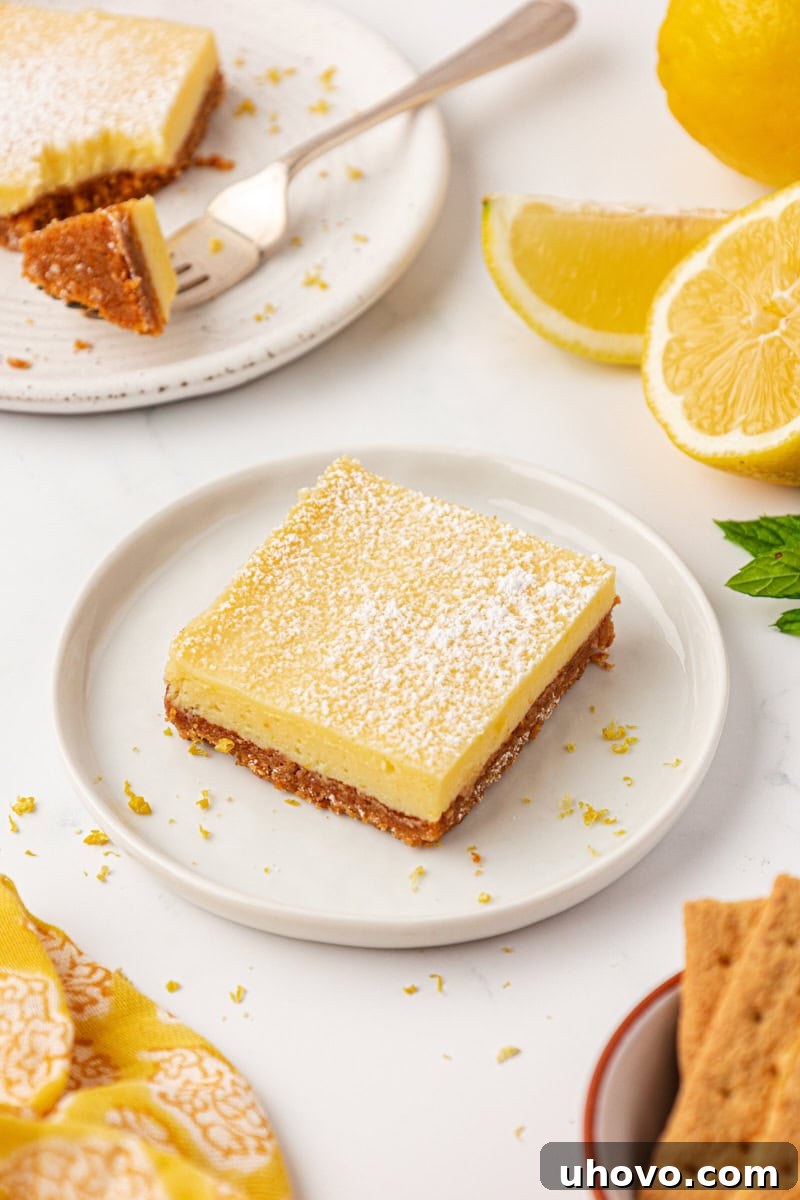 Tangy Lemon Icebox Bars Recipe — Cool, Zesty Dessert with Shortbread Crust 8 a lemon icebox bar topped with a sprinkle of powdered sugar