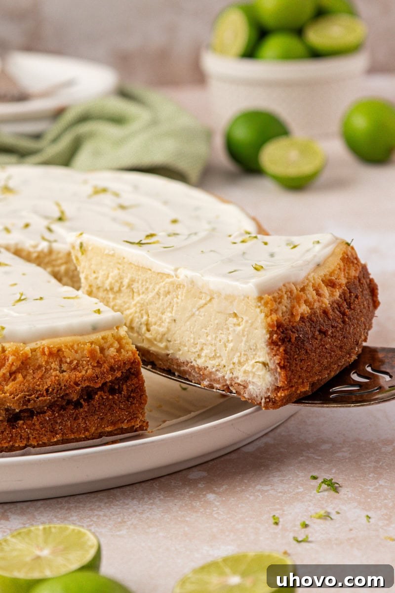 Creamy Key Lime Cheesecake Recipe: Zesty No-Bake Dessert 2 slice of Key lime cheesecake being removed from remaining cheesecake
