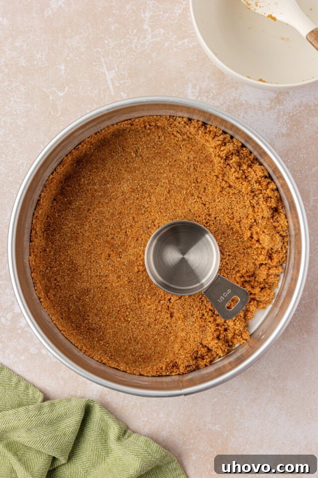 Creamy Key Lime Cheesecake Recipe: Zesty No-Bake Dessert 4 graham cracker crust mixture being pressed into a springform pan