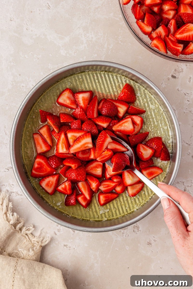 Strawberry Spoon Cake Recipe: Quick No-Bake Dessert for Summer 4 strawberries added to a pan with melted butter