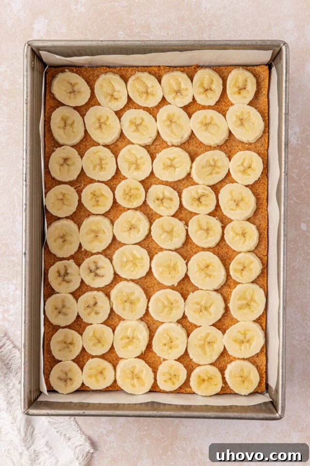 Creamy Banana Pudding Cheesecake Bars 5 banana slices in a single layer over a vanilla wafer crust