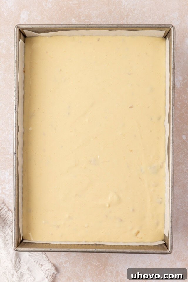 Creamy Banana Pudding Cheesecake Bars 6 banana cheesecake filling poured over bananas and crust in a baking pan