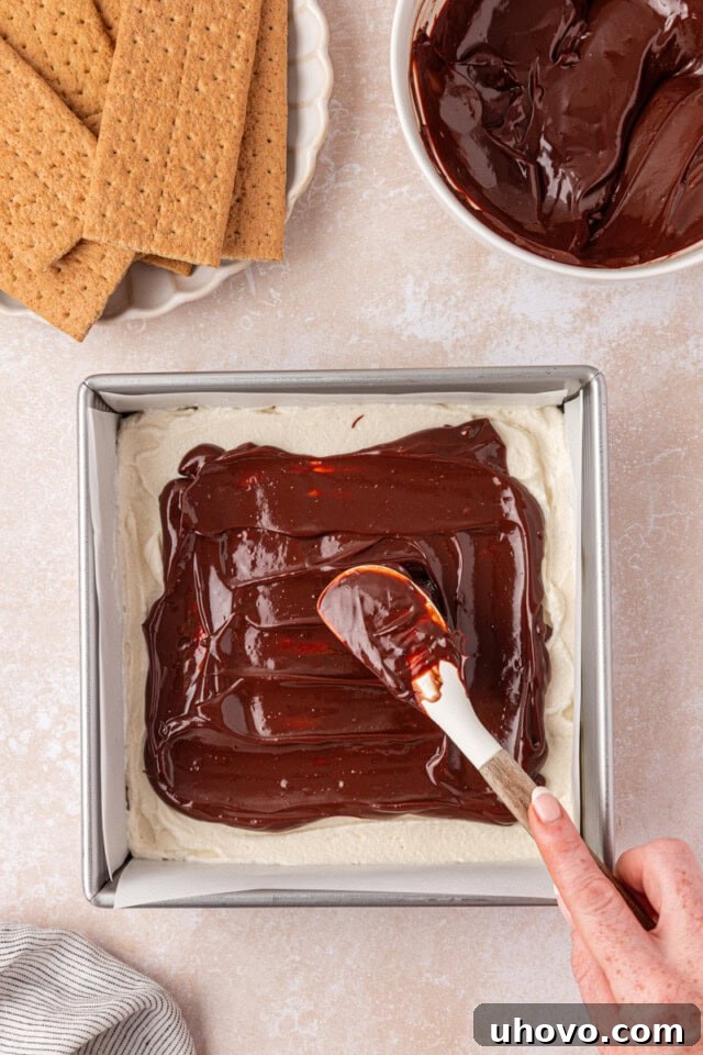 No-Bake S'mores Icebox Cake 5 overhead view of chocolate ganache being spread over marshmallow filling