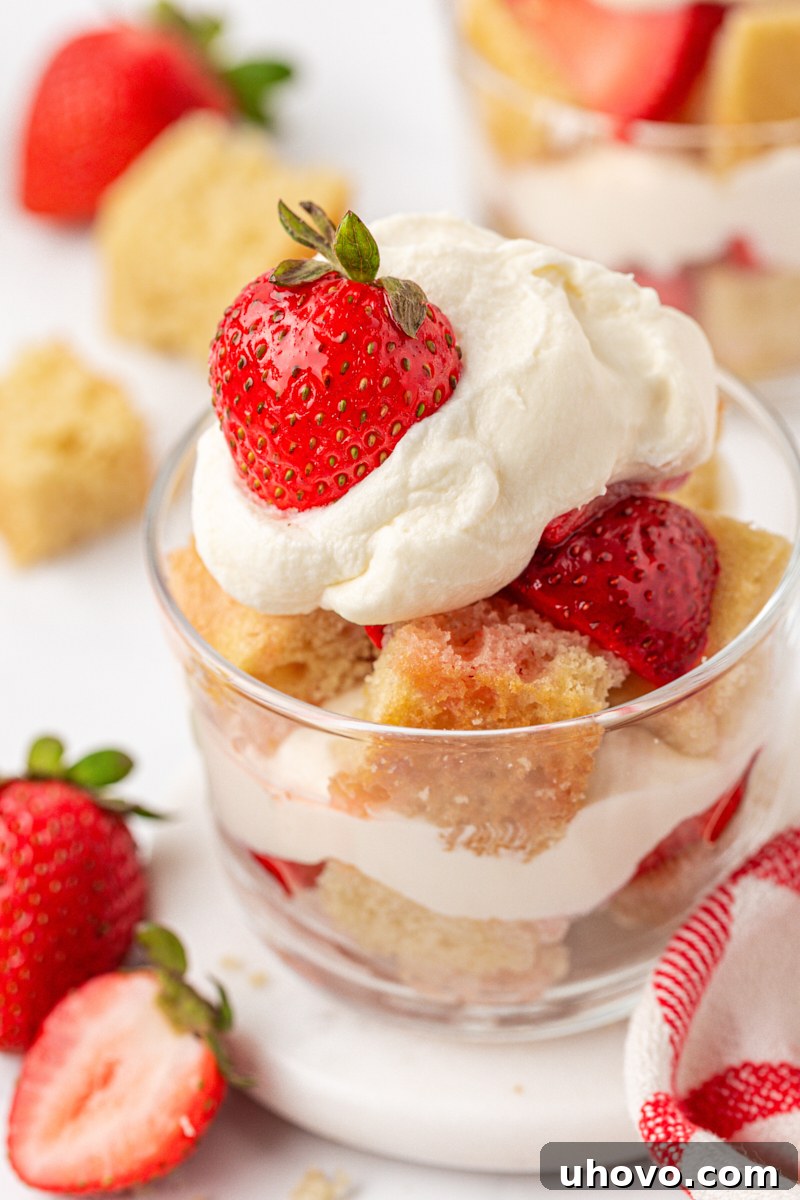 Mini Strawberry Shortcake Jars Recipe 2 close up of a strawberry shortcake jar, featuring layers of vanilla cake, macerated strawberries, and whipped cream