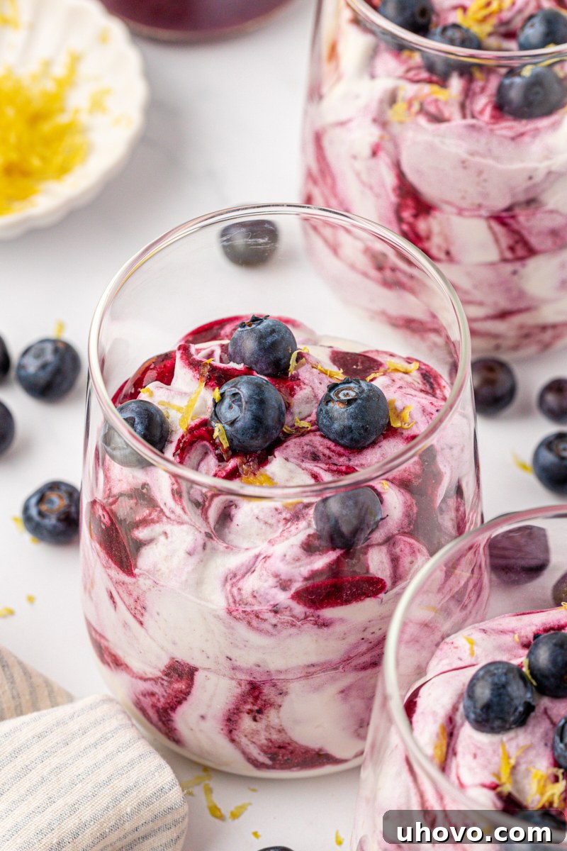 Creamy Blueberry Fool: Classic British Dessert Recipe 2 blueberry fool made with blueberry puree swirled into whipped cream, served in glasses and topped with fresh blueberries and lemon zest