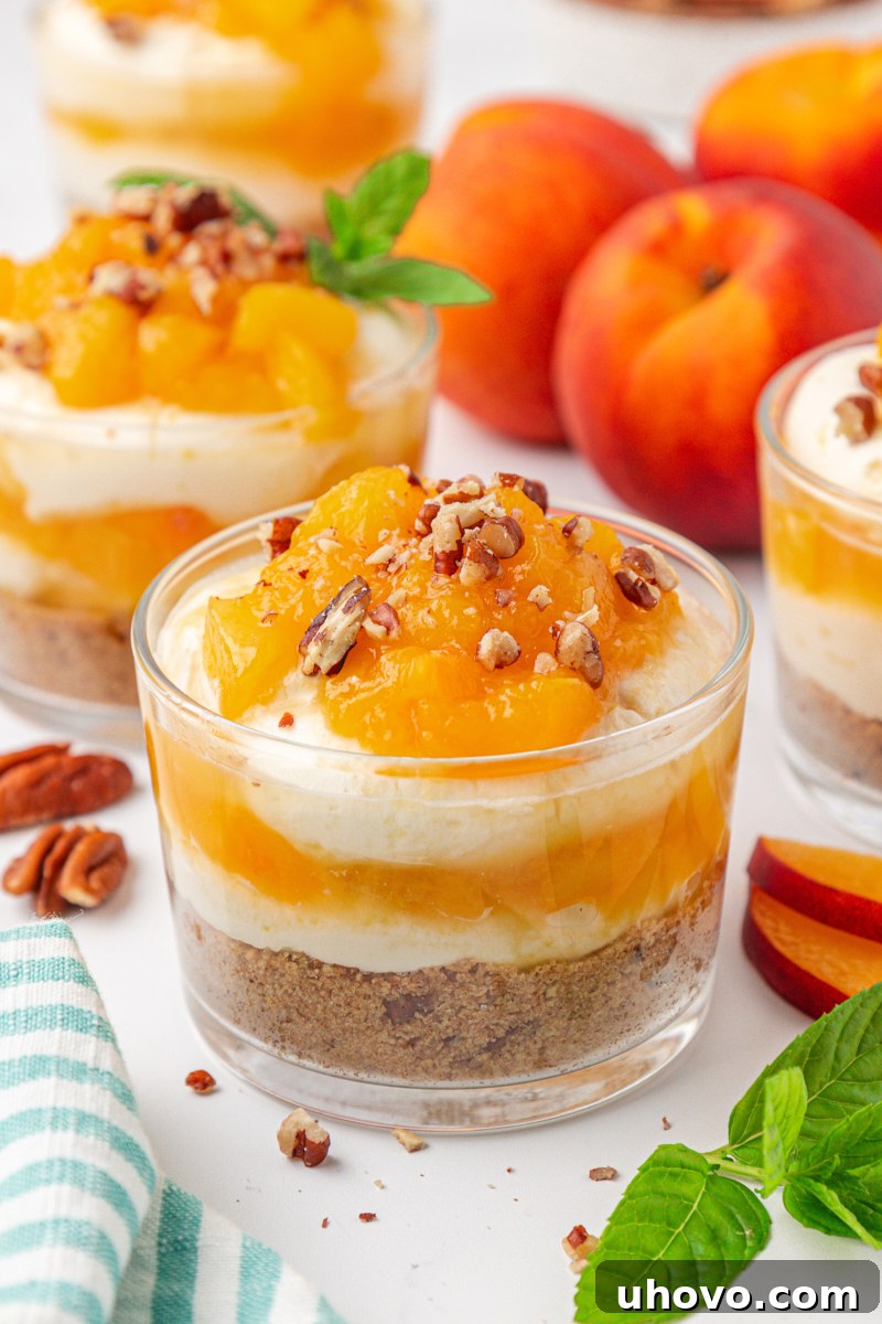 no-bake peach cheesecake jars with layers of graham cracker crust, cheesecake filling, and peach compote