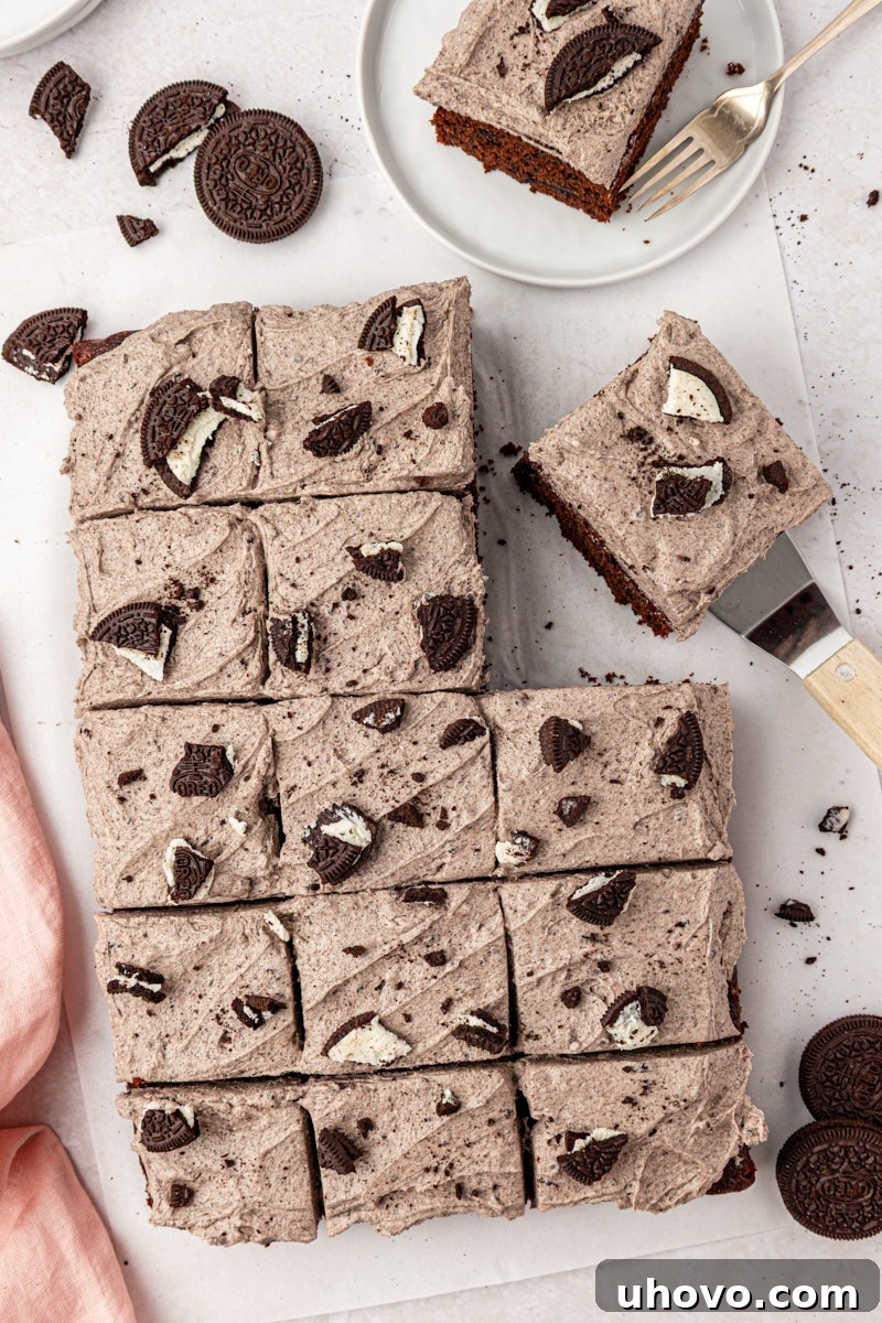 Decadent Oreo Sheet Cake with Creamy Oreo Frosting 10 overhead view of sliced Oreo sheet cake topped with cookies and cream frosting and more cookie pieces