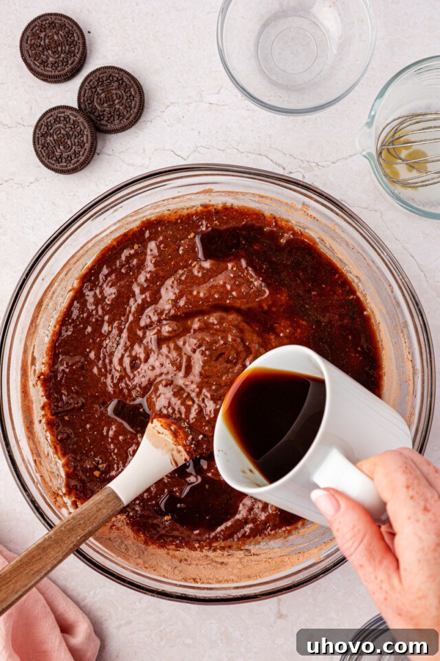 Decadent Oreo Sheet Cake with Creamy Oreo Frosting 5 hot coffee being stirred into chocolate cake batter