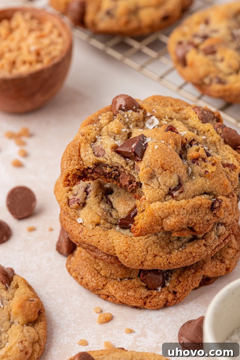 Gooey Loaded Chocolate Chip Cookies 11 stack of three bakery-style loaded chocolate chip cookies with a bite missing from the top cookie