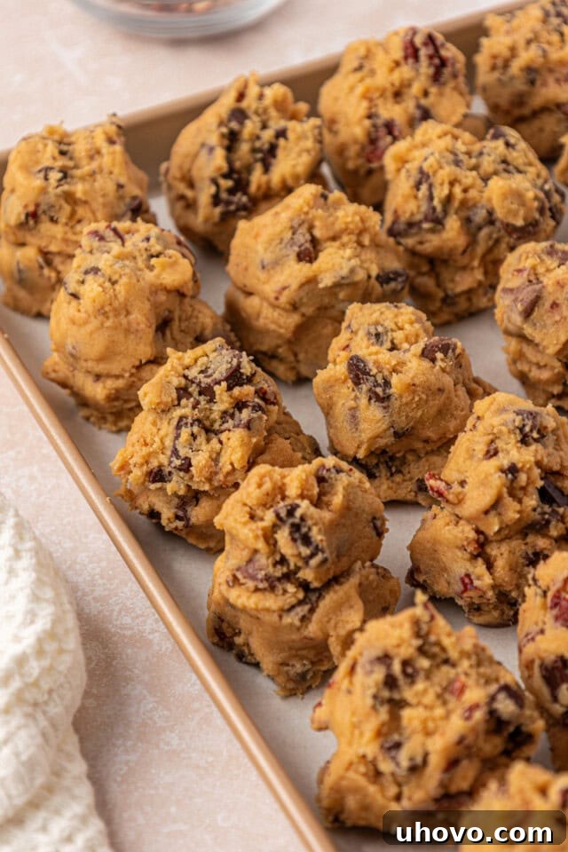 Gooey Loaded Chocolate Chip Cookies 7 loaded chocolate chip cookie dough shaped into rough, tall mounds on a baking sheet before chilling