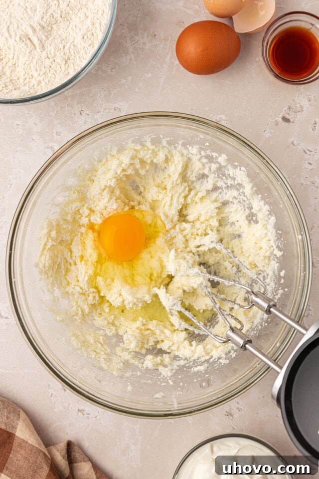 Classic Marble Loaf Cake Recipe 4 overhead view of egg added to creamed butter and sugar