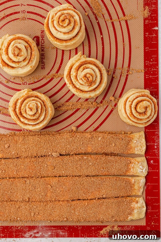 Overnight Cinnamon Roll Recipe for Fluffy Morning Pastry 7 overhead view of cinnamon roll dough rolled into spirals with remaining dough cut and ready to roll
