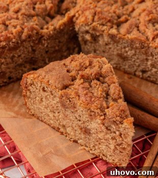 a slice of cinnamon streusel muffin cake alongside the remaining cake