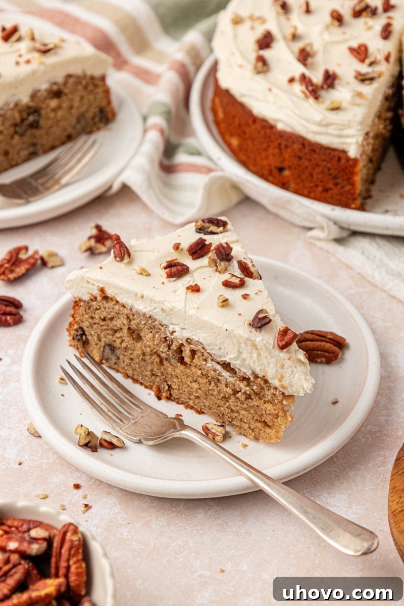 a slice of maple cake topped with maple frosting and toasted pecans