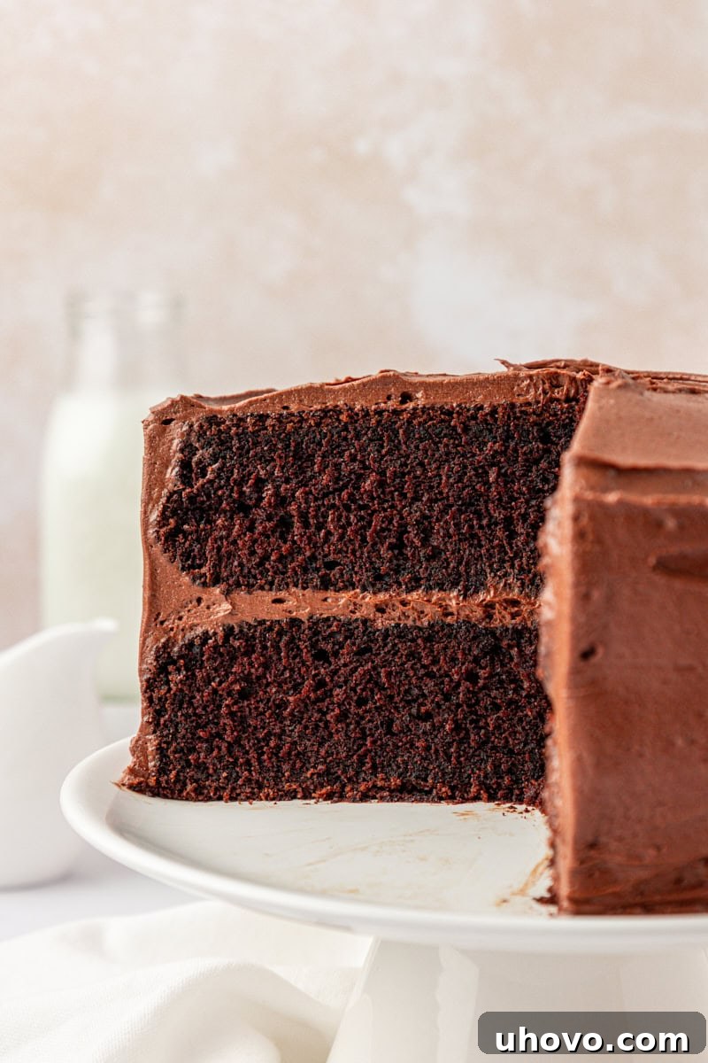 close up of partially sliced devil's food cake with chocolate buttercream frosting