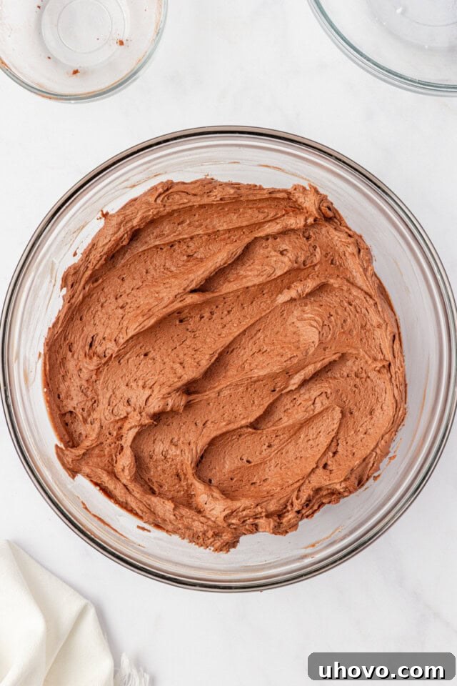 overhead view of chocolate buttercream frosting in a mixing bowl