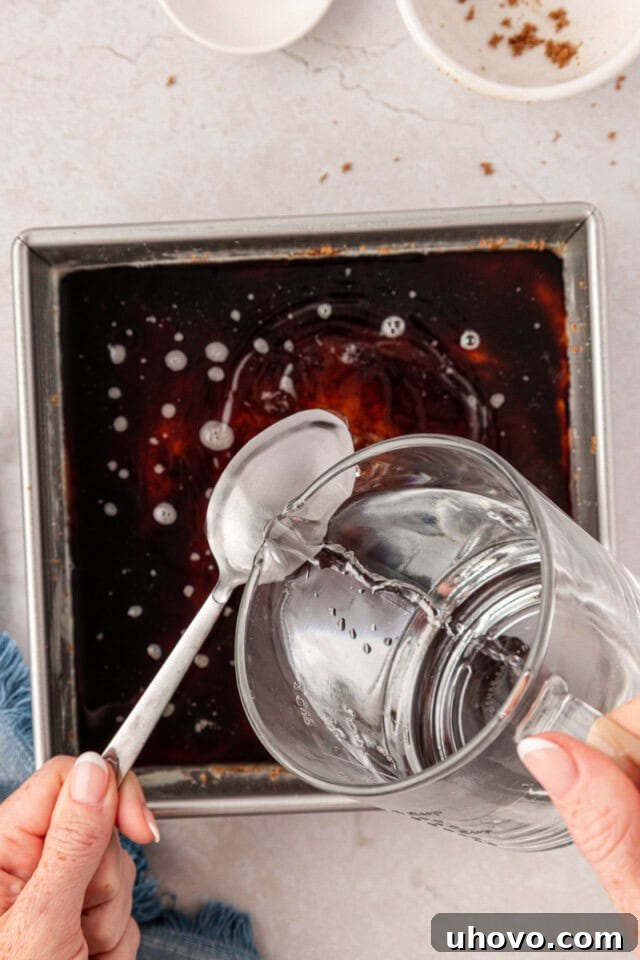 hot water poured over the back of a spoon onto cake batter in a square baking pan