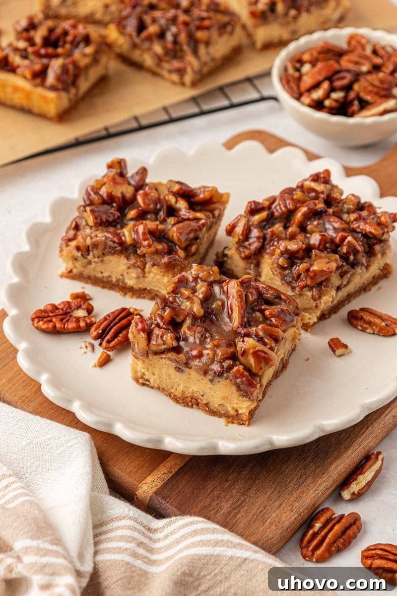 three pecan pie cheesecake bars on a white plate